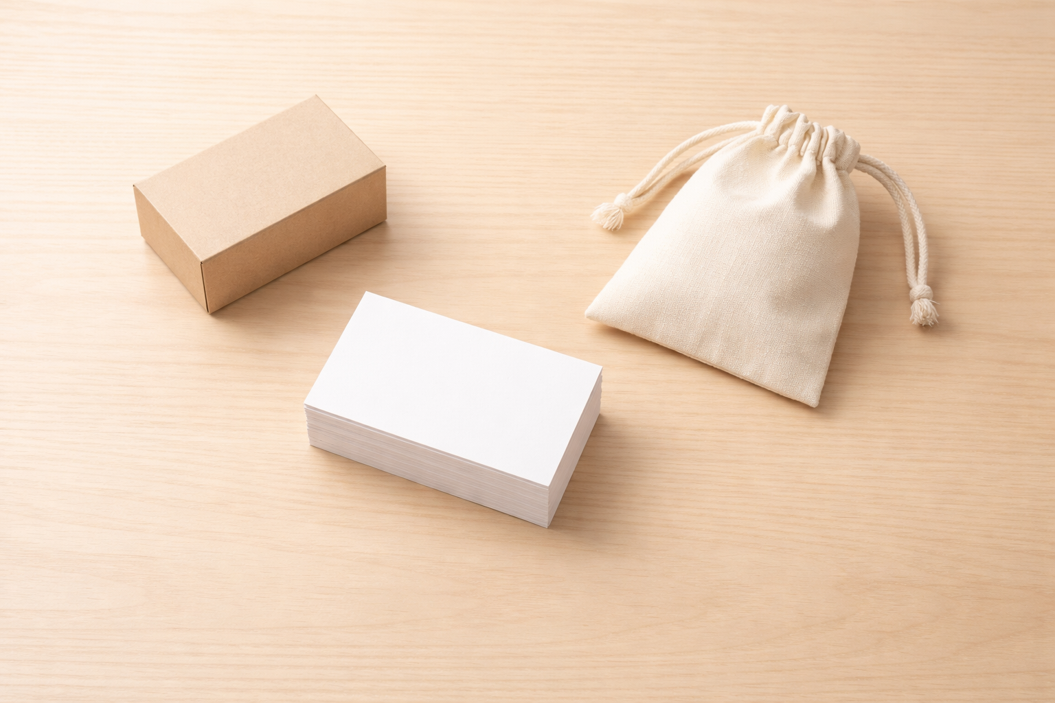 木のテーブルに小箱と巾着袋、白いカード束が並ぶ写真（原因を分けて考えるイメージ）
